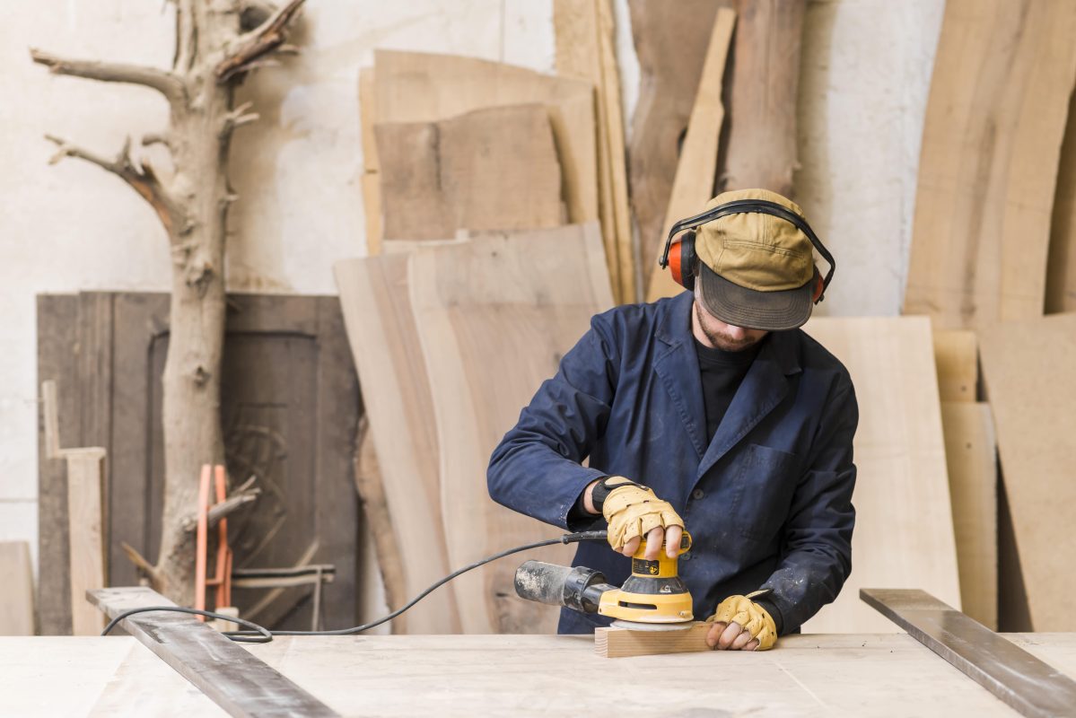 close-up-male-carpenter-using-electric-sander-wood-min